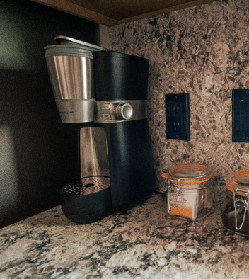 a coffee maker sits on top of a granite countertop