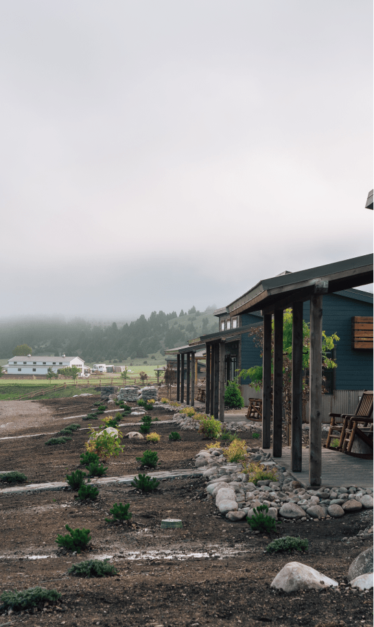 multiple cabins in a row with foggy hills in the background