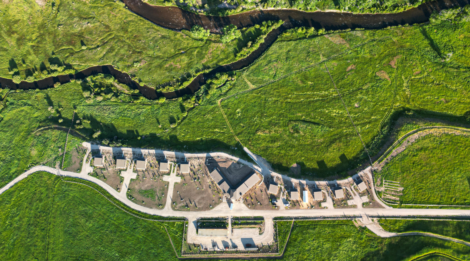 aerial view of multiple buildings in a green field