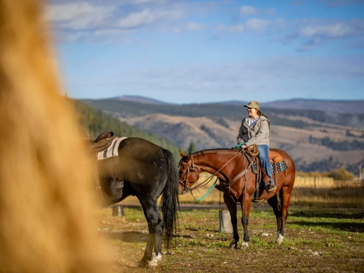 a woman riding a horse in the countryside of Montana