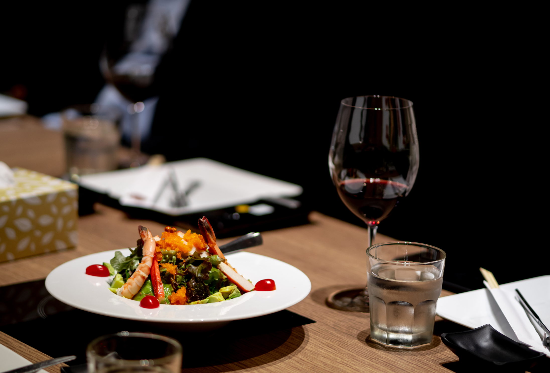 a plate with food and a glass of wine on a dining table