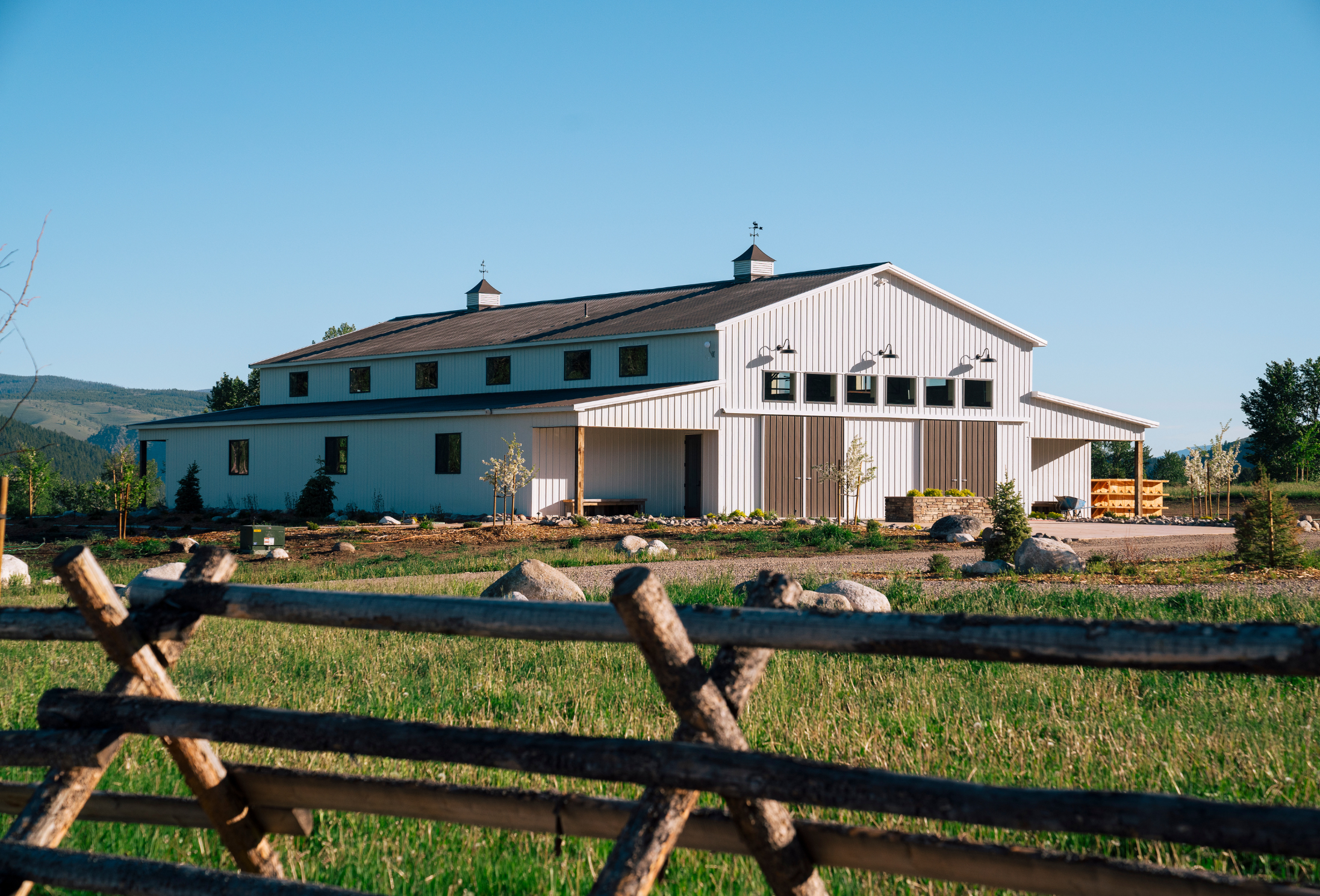 a large white barn in a grassy field