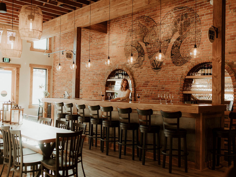 inside a restaurant with a bar and black bar stools