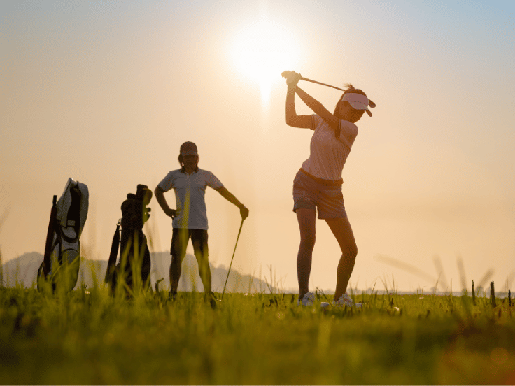 group of people golfing in a field