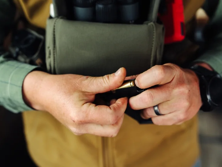 a marksmen reloads a rifle magazine