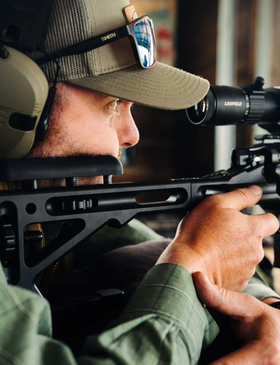 a man holds a rifle and aims