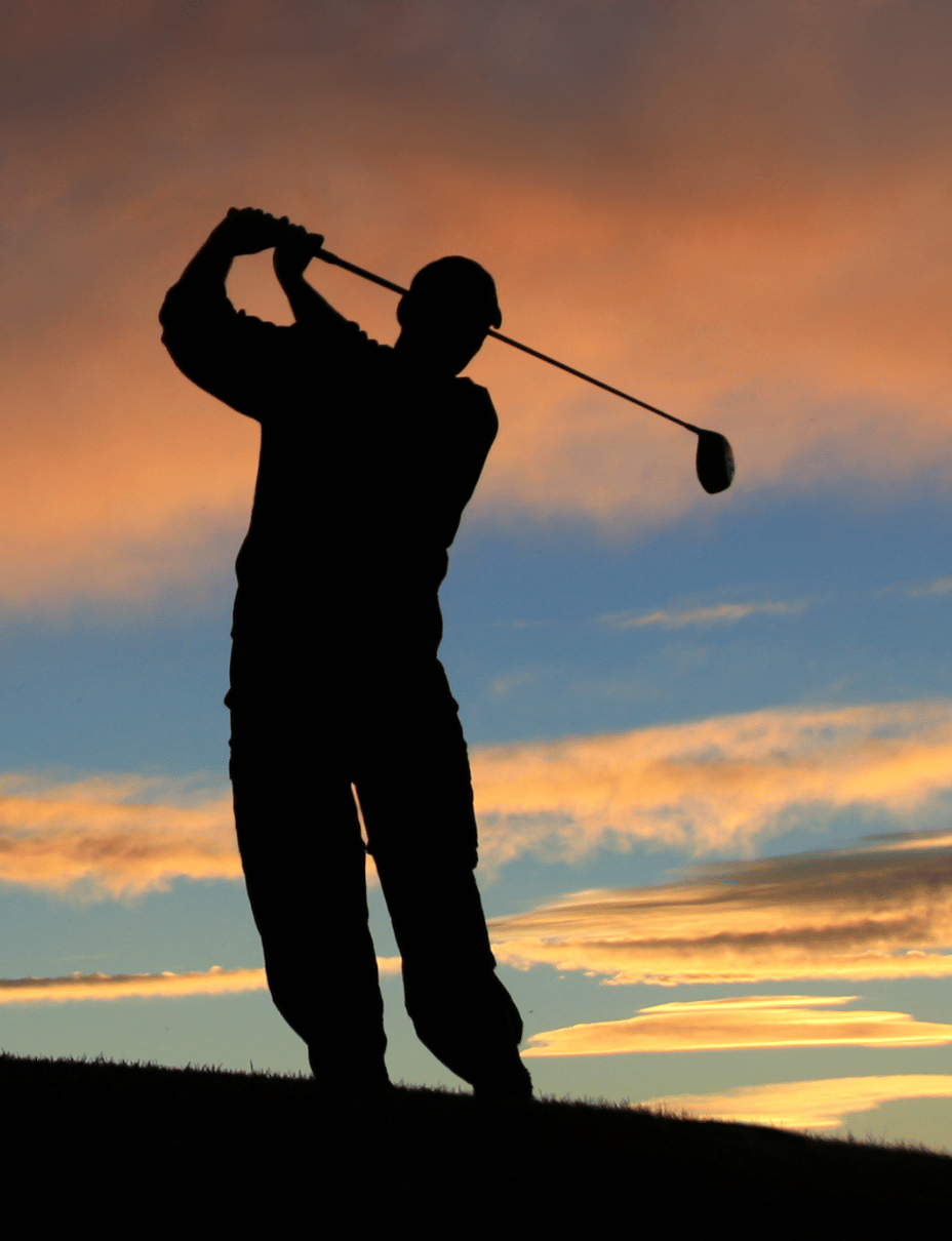 golfer swings a club at sunset on a hill