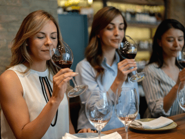 three women tasting wine at a table