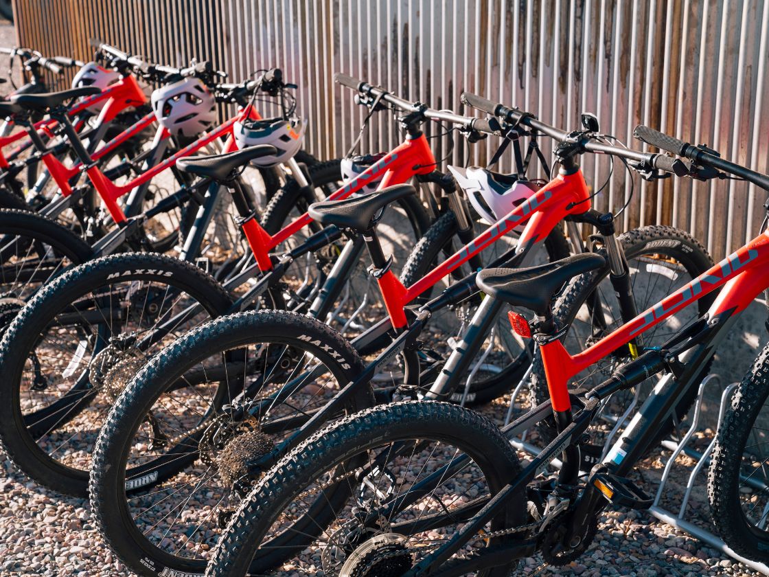 several mountain bikes at a metal wall
