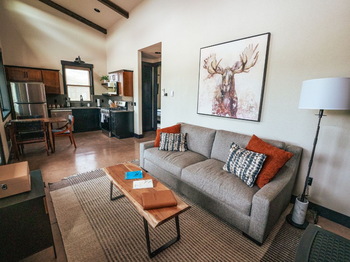 the inside of a home with a nice couch, coffee table, and a kitchen