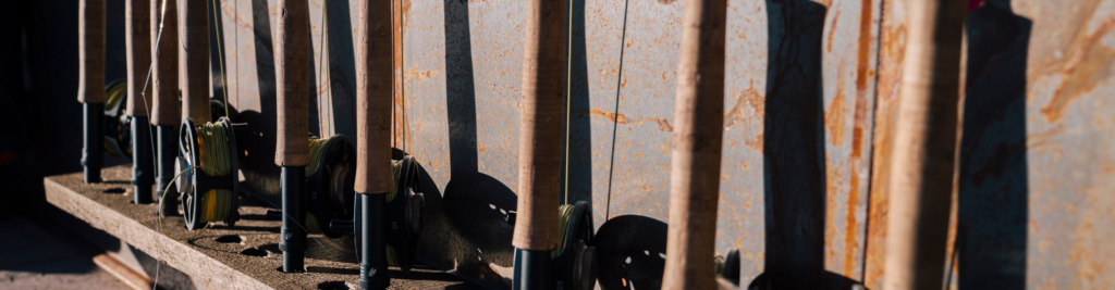 a rack of fly fishing rods up against a wall