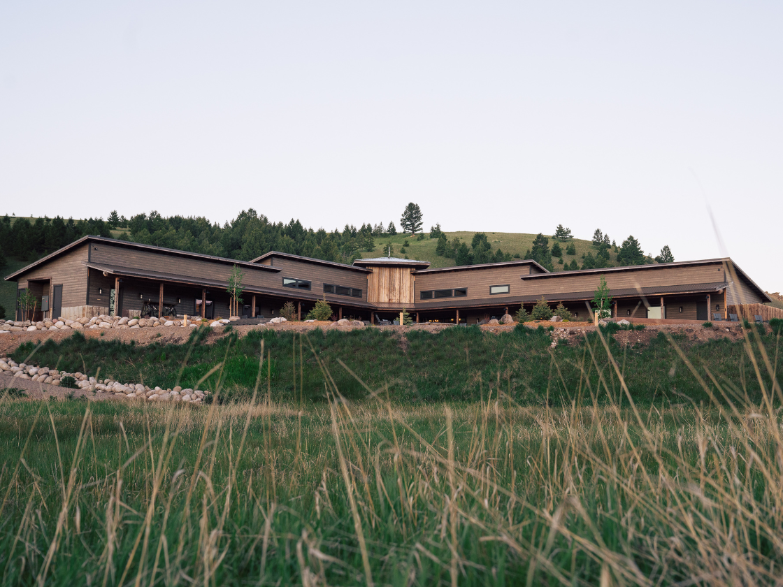 a large lodge on a green grassy hill