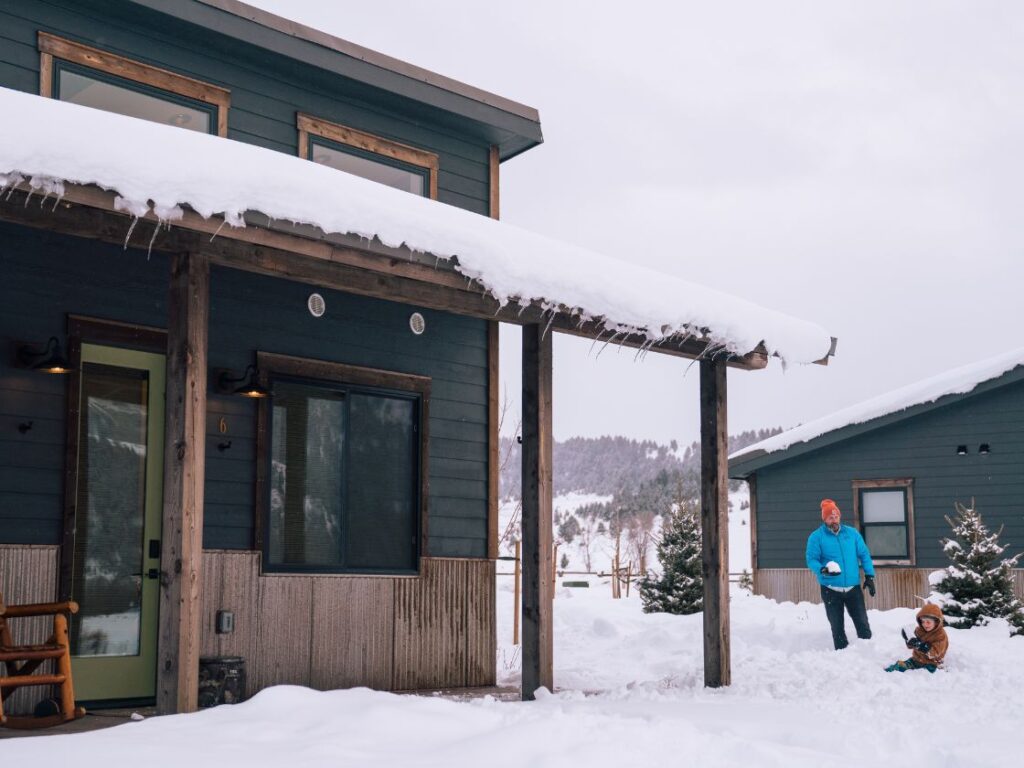 a snow covered building with two people playing in the snow