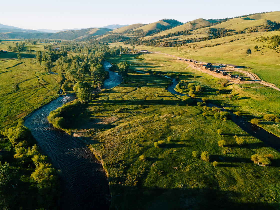 a large, green valley with a river running through it