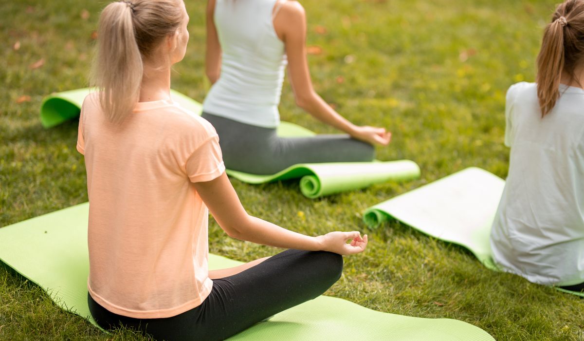 women doing yoga on the grass