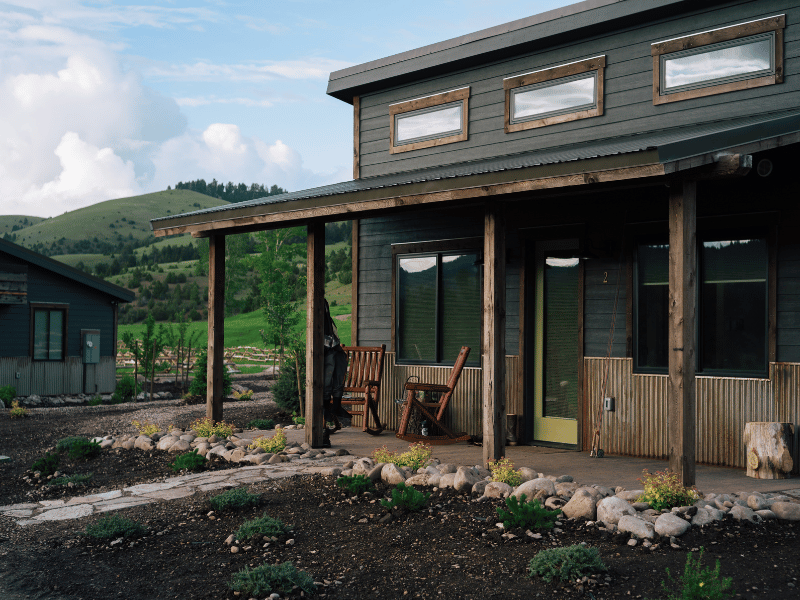 a luxurious cabin in front of a grassy mountain