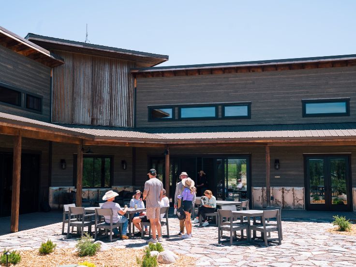 a group of people sitting outside a large lodge building