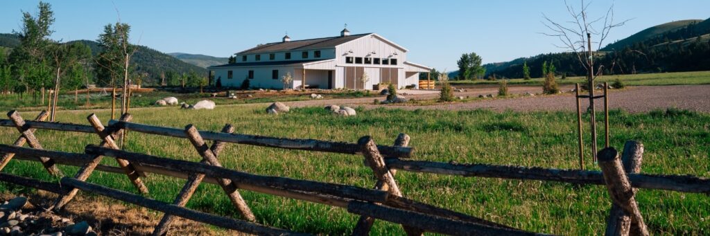 a white barn in the middle of a field