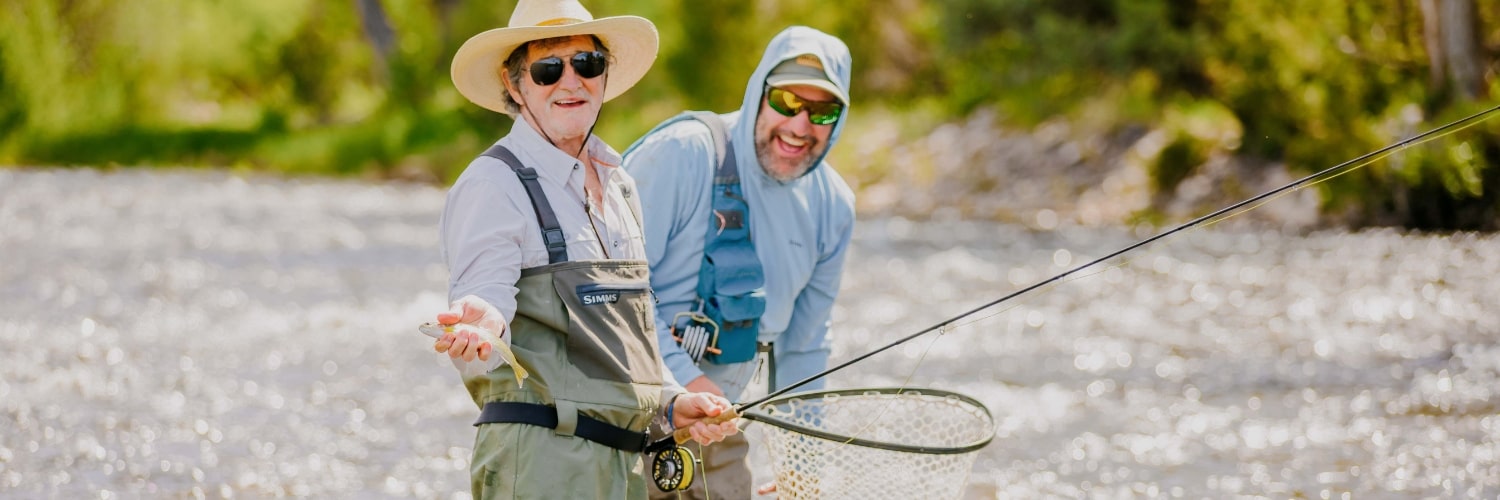two men fly fishing in a river