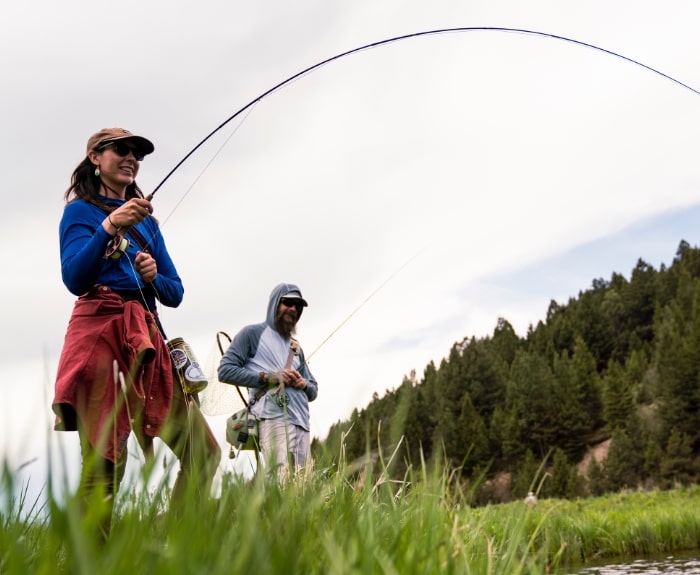 a woman holding a fly fishing rod
