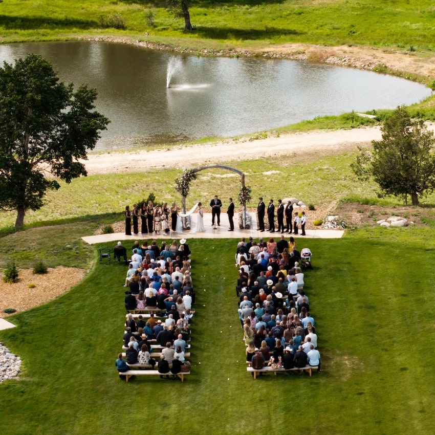 a wedding outdoors overlooking a pond