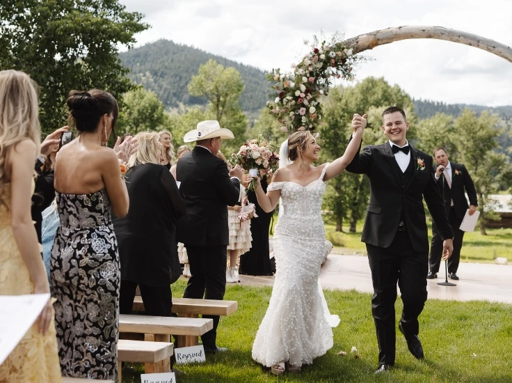 a bride and groom walk down the aisle in their wedding