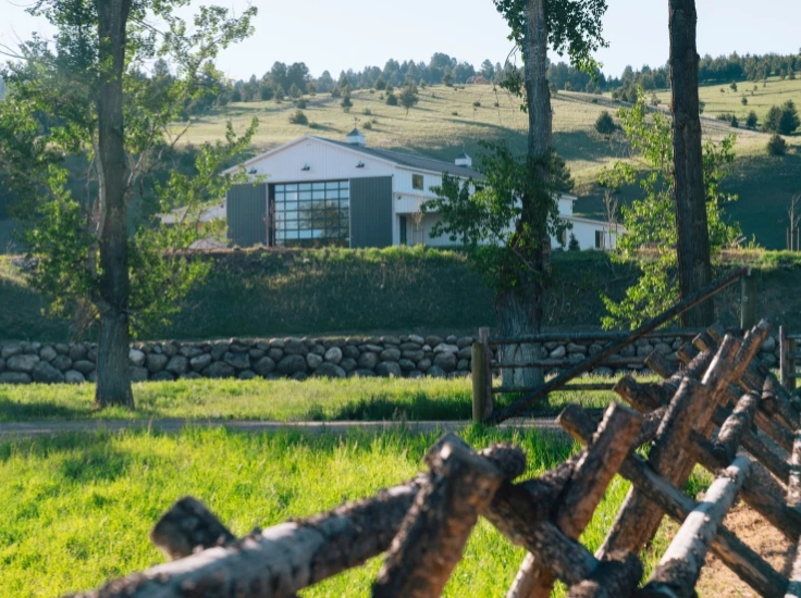 a large white barn on a hillside
