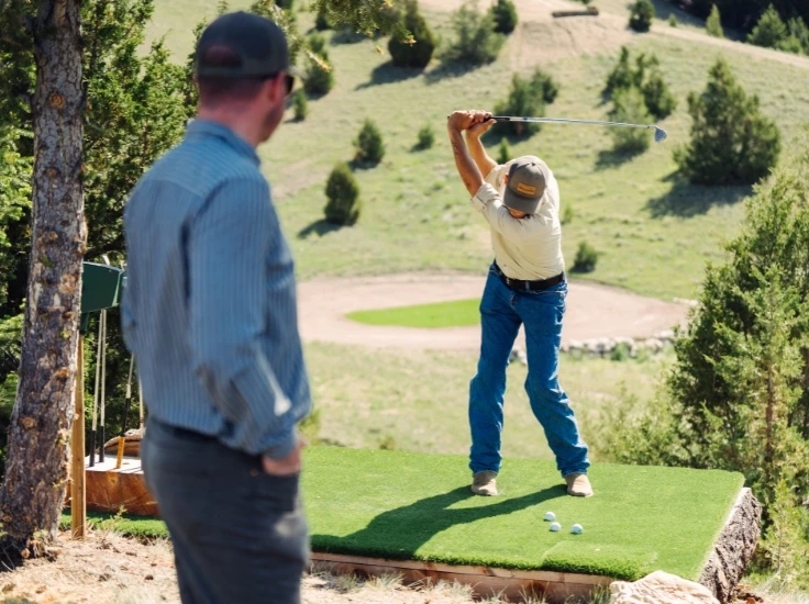 two men playing golf in the woods