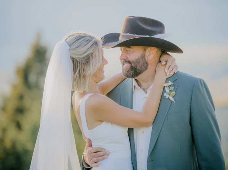 a bride and groom looking each other in the eyes