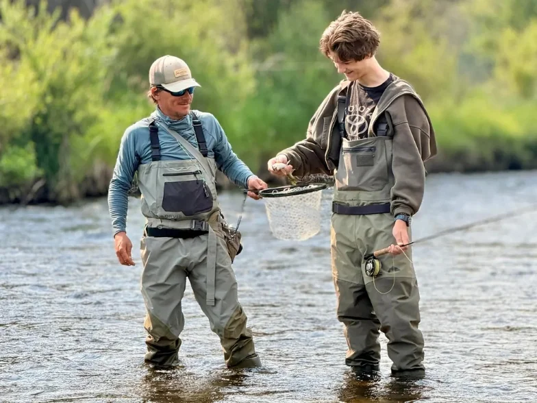 two anglers stand in a river while fly fishing