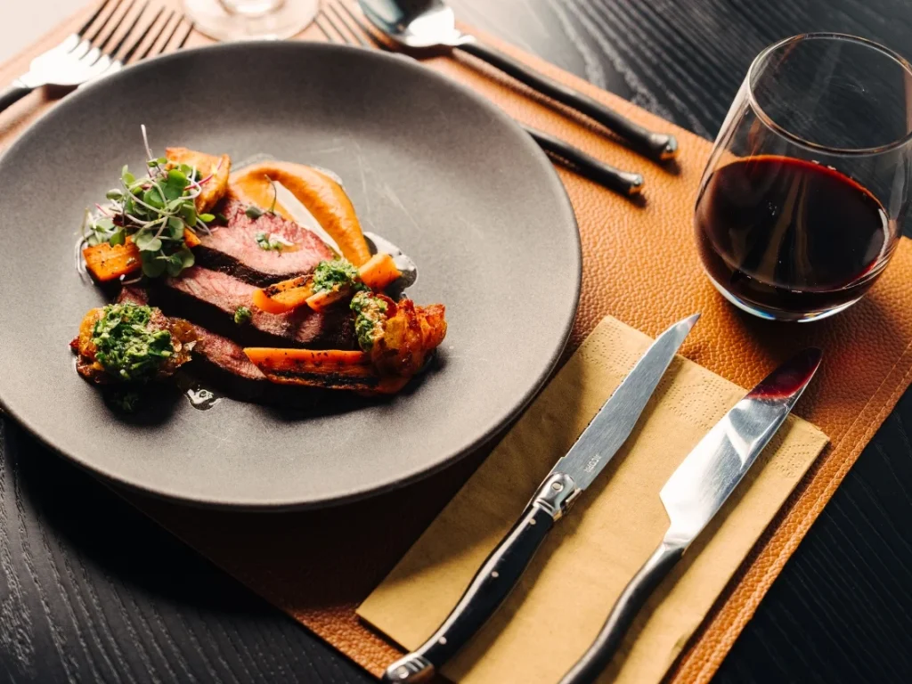 a plate full of food next to a glass of red wine