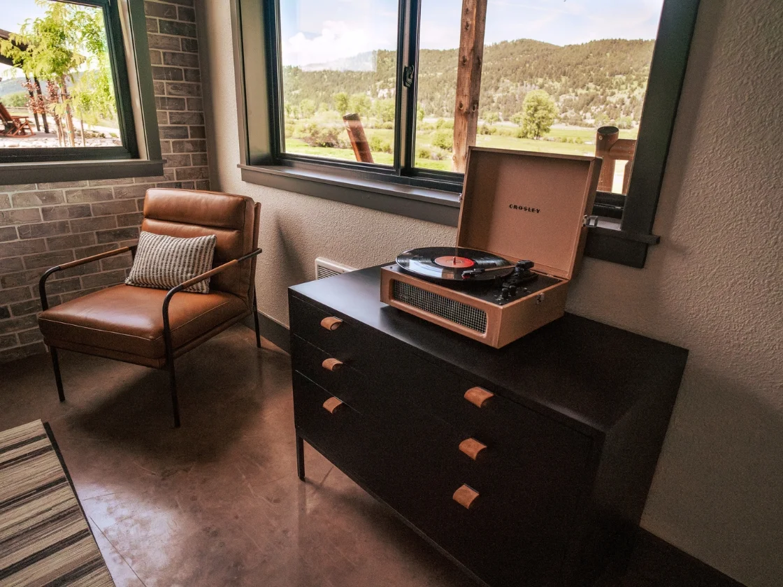 a record player and a chair next to a window